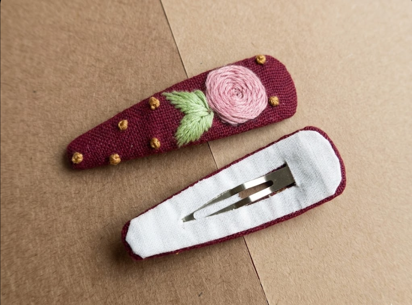 Two decorative sheaths on a brown surface, one with a rose design and the other with a white interior.