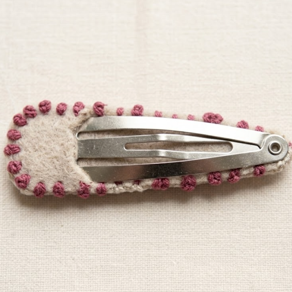Hair clip with pink beads on a beige background