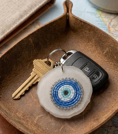 Keychain with decorative eye design on a wooden surface
