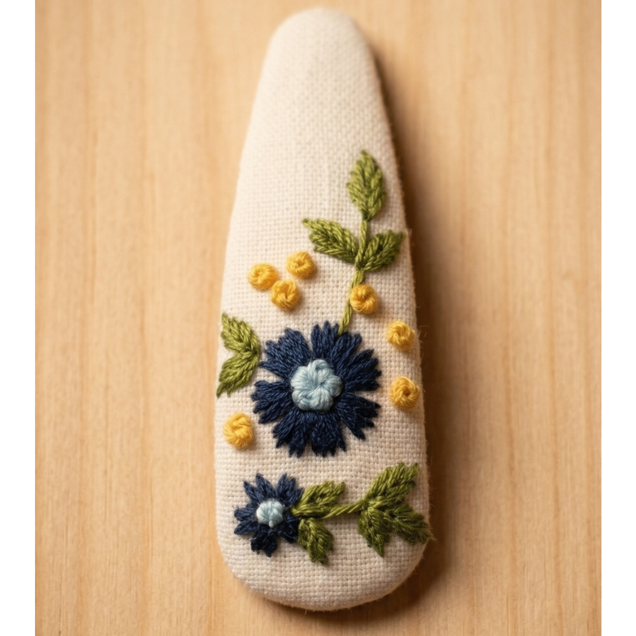 Decorative stone with embroidered flowers on a wooden surface