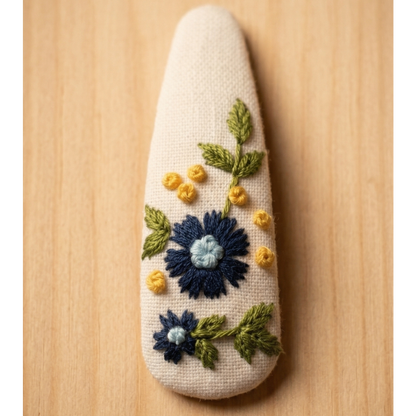 Decorative stone with embroidered flowers on a wooden surface