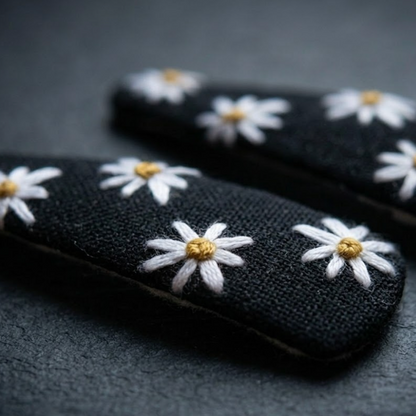 Black gloves with white daisy flowers on a dark background